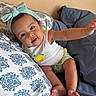 baby, child, headband, bow, smiling, pillow, bed, blanket, clothing, cute, infant, person, skin, arm, foot, indoors, happy, face, sitting, toddler