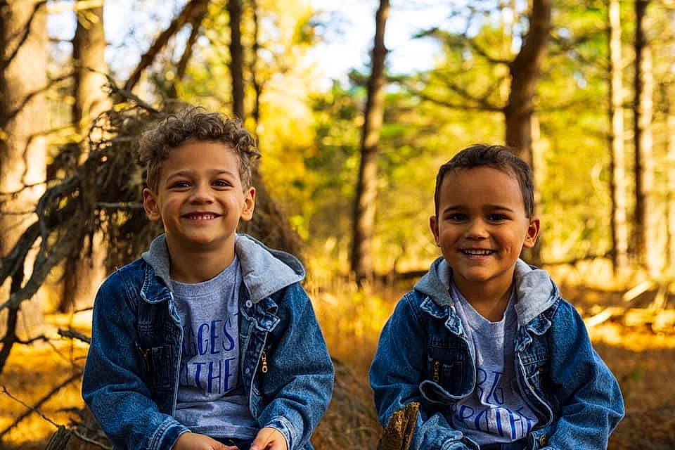 Chance is registered to the contest to win money with this photo: adaptation, botany, face, facial_expression, fun, grass, happy, interaction, joy, leisure, natural_landscape, people_in_nature, person, recreation, smile, sunlight, t_shirt, toddler, tree, trunk