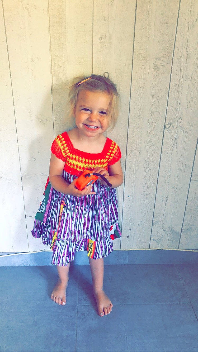 élya a rejoint le concours — aidez-le/la à gagner de superbes lots ! arm, baby_toddler_clothing, clothing, day_dress, dress, electric_blue, face, happy, joy, magenta, one_piece_garment, person, pink, purple, shoulder, skin, sleeve, smile, standing, toddler