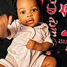 baby, infant, onesie, sock, blanket, curly_hair, cute, indoor, portrait, child, smiling, hand, face, lying_down, clothing, soft_toys, cozy, young_child, expression, person