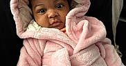 Sarayah is registered to the contest to win money with this photo: baby, child, pink_robe, bunny_ears, cute, infant, face, portrait, couch, black_cushion, soft_texture, clothing, indoor, person, young_child, expression, cozy, wrapped, seated, adorable