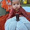 autumn, baby, blanket, bow, child, curious, face, fall, forest, grass, hair_bow, infant, knitted_pumpkin, nature, orange, outdoor, portrait, pumpkin, rustic, sitting