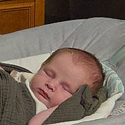 Luke is registered to the contest to win money with this photo: baby, baby_seat, blanket, child, cozy, cushion, face, head, indoors, infant, knit, nap, peaceful, person, portrait, relaxation, rest, sleeping, soft_lighting, wooden_furniture