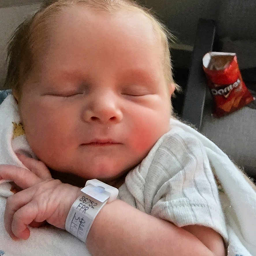 Luke joined the competition — help win amazing prizes! newborn, baby, sleeping, blanket, hospital_wristband, indoor, baby_clothing, face, infant, hand, furniture, chair, snack, doritos, relaxing, portrait, peaceful, resting, child, person