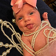 Sophia joined the competition — help win amazing prizes! baby, child, infant, pink_bow, pearl_necklaces, tongue_out, cute, playful, closeup, portrait, skin, headband, accessories, tulle, fabric, chubby_cheeks, expression, laying_down, soft_focus, adorable