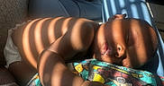 Zuri is registered to the contest to win money with this photo: baby, infant, sleeping, portrait, indoors, blanket, couch, sunlight, shadows, striped_light, colorful, resting, lying_down, face, hand, diaper, home, close_up, peaceful, photography
