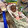 Zuri joined the competition — help win amazing prizes! baby, infant, child, shopping_cart, grocery_store, blanket, pink_bow, bottle, milk_bottle, baby_clothing, seated, portrait, face, looking_at_camera, indoors, supermarket, apples, groceries, food, safe