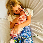 Brooklyn joined the competition — help win amazing prizes! child, baby, newborn, holding, kiss, flower, rose, bed, bedding, white, blue, floral, pants, headband, sleeping, tender, love, family, portrait, indoor