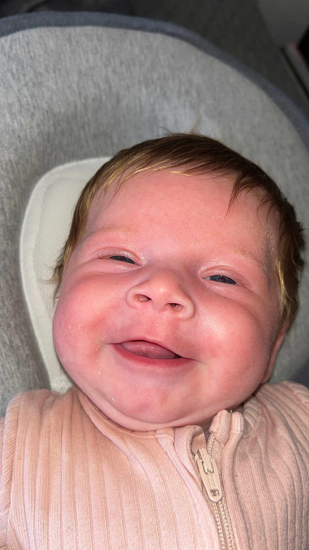 Nevaeh is registered to the contest to win money with this photo: baby, smiling, face, infant, pink_clothing, zipper, closeup, cheeks, skin, person, happy, head, hair, young_child, cute, indoors, apparel, fabric, babywear, portrait