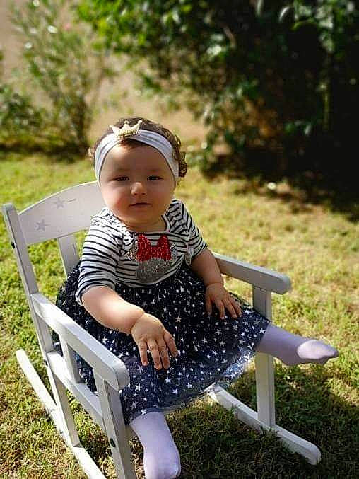 Ylona a rejoint le concours — aidez-le/la à gagner de superbes lots ! baby, baby_toddler_clothing, botany, chair, child, furniture, garden, grass, grass_family, leisure, person, plant, shoe, sitting, skin, smile, spring, summer, table, toddler