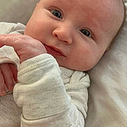 Lucas is registered to the contest to win money with this photo: baby, infant, face, eyes, hand, clothing, sleeve, blanket, portrait, cute, skin, expression, newborn, person, child, soft, cozy, indoor, sleepwear, closeup