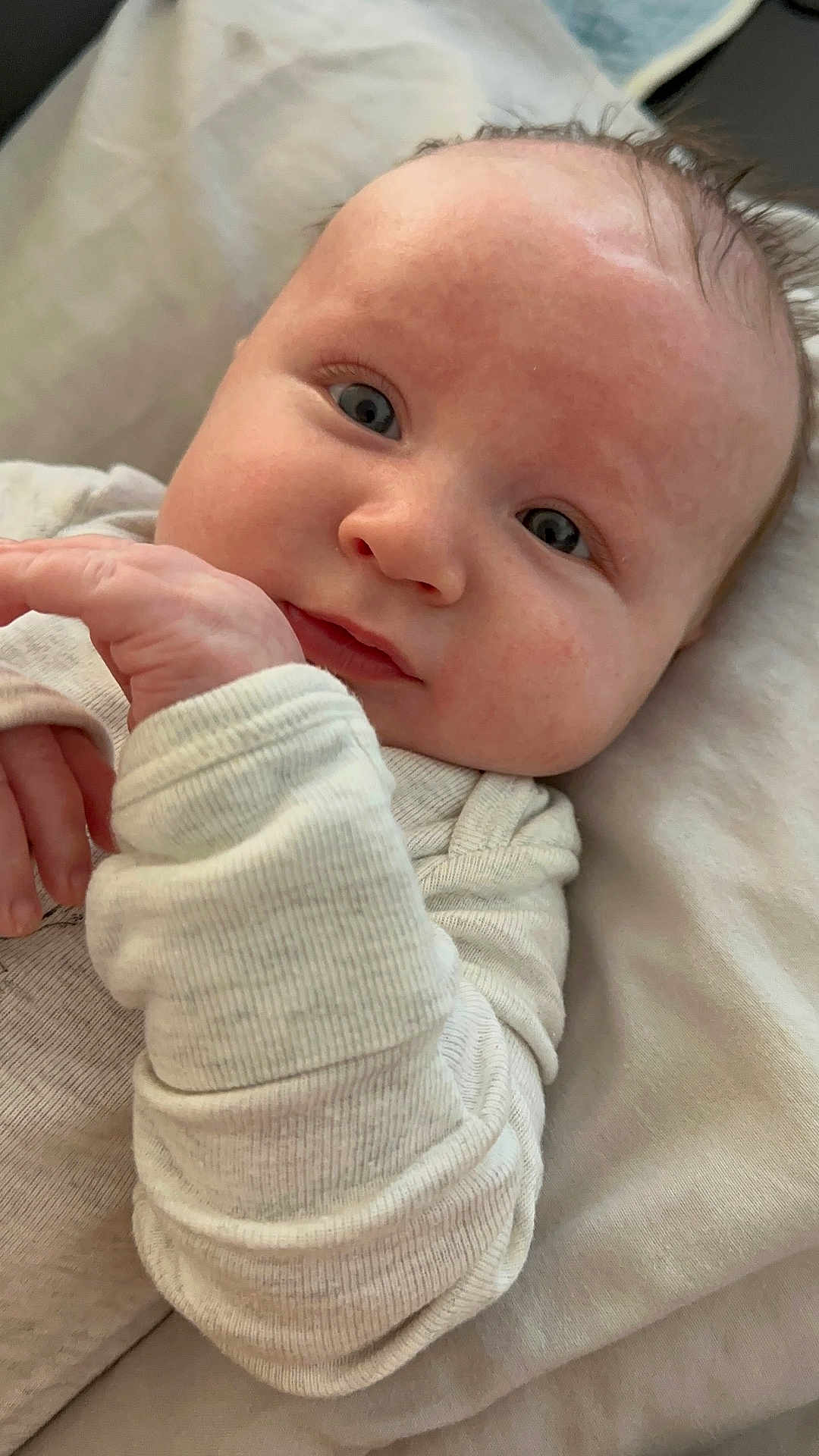 Lucas is registered to the contest to win money with this photo: baby, infant, face, blue_eyes, close_up, skin, hand, clothing, blanket, resting, portrait, cute, soft_light, expression, newborn, young_child, cozy, sleepwear, indoor, person