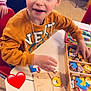 Loevan participe au concours pour gagner de l'argent avec cette photo : child, boy, puzzle, wooden_toy, table, red_chair, yellow_chair, classroom, scrape, face, hand, sweater, toy_box, playtime, smiling, indoor, person, game, education, heart_emoji