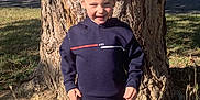 Loevan participe au concours pour gagner de l'argent avec cette photo : child, boy, smile, tree, outdoor, sunlight, nature, clothing, sweatshirt, pants, shoes, grass, daylight, casual, standing, young, happy, portrait, park, person