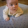 baby, infant, blanket, star_pattern, floor, wood_floor, clothing, long_sleeve, face, eyes, hand, indoor, curious, child, person, portrait, soft_texture, crawling, head, young