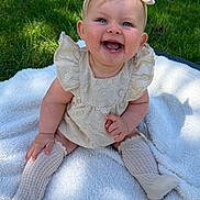 Henley joined the competition — help win amazing prizes! baby, child, smiling, blue_eyes, headband, bow, dress, knit_socks, blanket, outdoor, grass, sunlight, happy, cute, sitting, infant, portrait, person, nature, playful