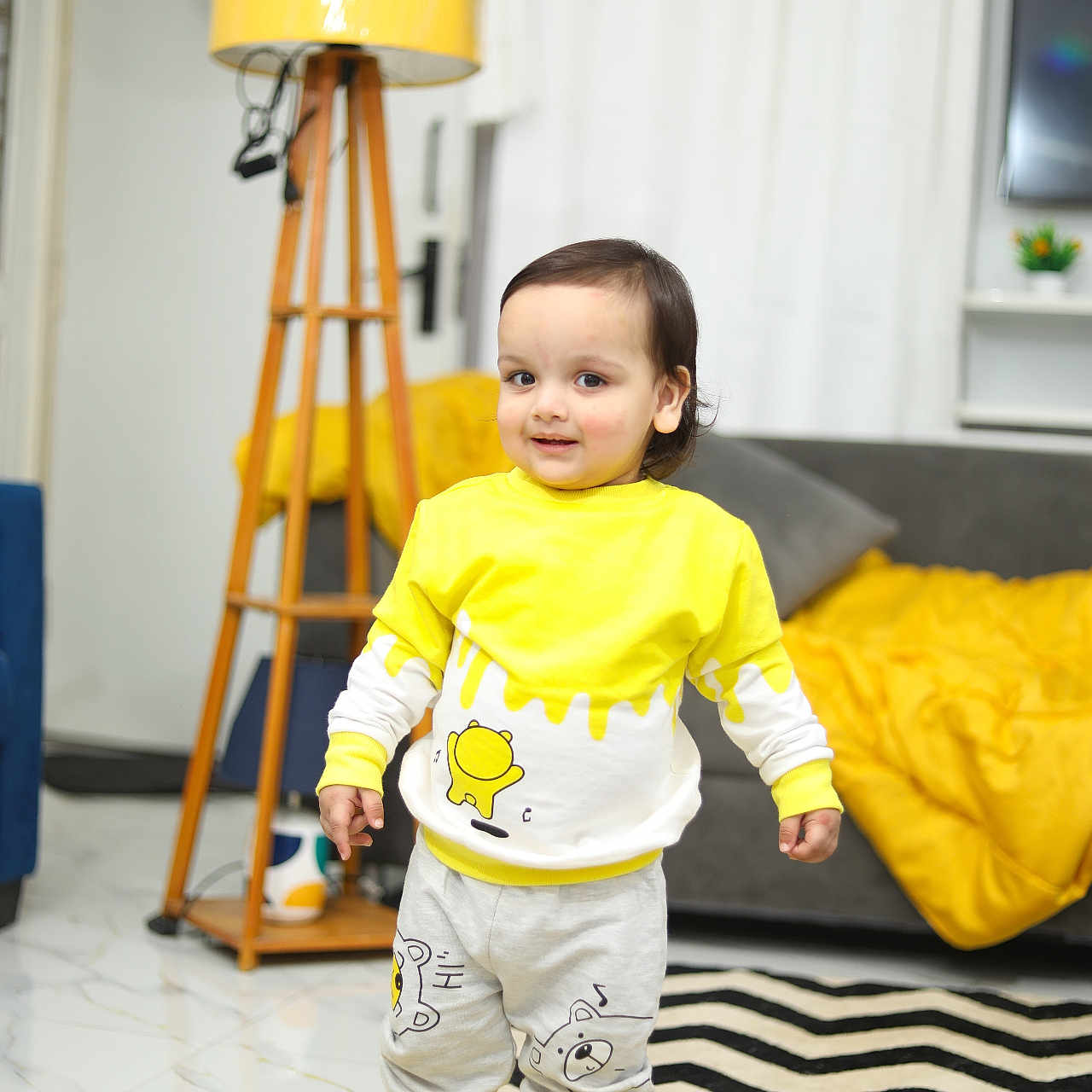 Kriyansh is registered to the contest to win money with this photo: blanket, cartoon_design, child, curtains, cushion, floor, happy, home_decor, indoor, lamp, living_room, person, rug, smiling, sneakers, sofa, toddler, toy_keyboard, wooden_lamp_stand, yellow_clothing