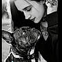 woman, dog, french_bulldog, portrait, black_and_white, outdoor, sunlight, close_up, leash, jewelry, ring, necklace, long_hair, pet, face, expression, animal, fashion, affection, bond