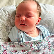 Maisie joined the competition — help win amazing prizes! baby, sleeping, blanket, floral, onesie, rainbow_pattern, pillow, soft_texture, infant, peaceful, closeup, child, resting, cute, newborn, face, skin, head, indoors, portrait