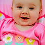 Myleigh is registered to the contest to win money with this photo: baby, child, smiling, pink_shirt, flowers, cartoon_flowers, happy, face, blue_eyes, cute, infant, closeup, portrait, soft_background, colorful, indoors, young_child, sitting, apparel, cheerful