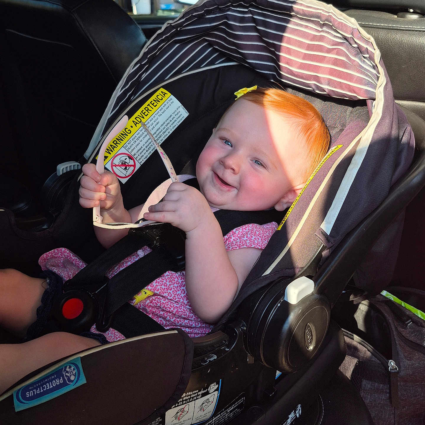 Myleigh joined the competition — help win amazing prizes! baby, car_interior, car_seat, child, cute, happy, head_support, infant, person, pink_clothing, red_hair, safety, seat, seatbelt, smile, sunglasses, sunlight, sunshine, toddler, vehicle