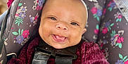 Jade is registered to the contest to win money with this photo: baby, babylaughing, bodypart, clothing, coat, cushion, face, finger, hand, happy, hat, head, jacket, person, photography, portrait, purple, smile, transportation, vehicle