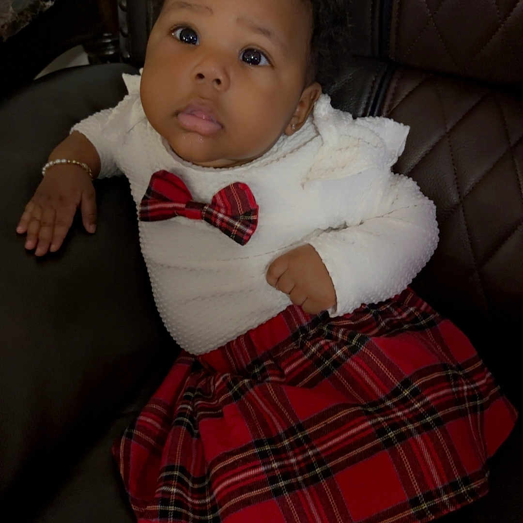 Jade joined the competition — help win amazing prizes! accessories, baby, bodypart, chair, clothing, couch, dress, face, finger, formalwear, furniture, hand, head, person, photography, portrait, sitting, skirt, tartan, tie