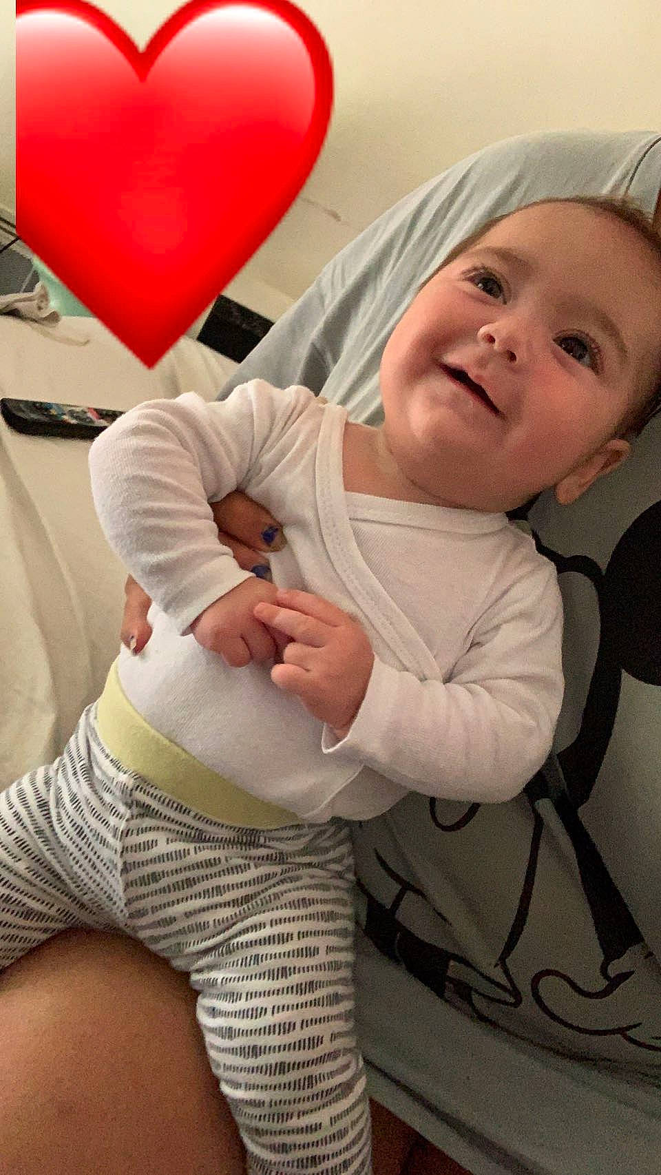 Brookline a rejoint le concours — aidez-le/la à gagner de superbes lots ! baby, baby_toddler_clothing, balloon, child, comfort, finger, gesture, hand, happy, human_body, human_leg, joy, outerwear, person, pink, sleeve, smile, textile, thigh, toddler