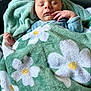 Timothé a rejoint le concours — aidez-le/la à gagner de superbes lots ! baby, blanket, child, close_up, cozy, cute, daisies, face, flower_pattern, green_blanket, hand, indoors, infant, newborn, peaceful, portrait, resting, sleeping, soft_texture, wrapped