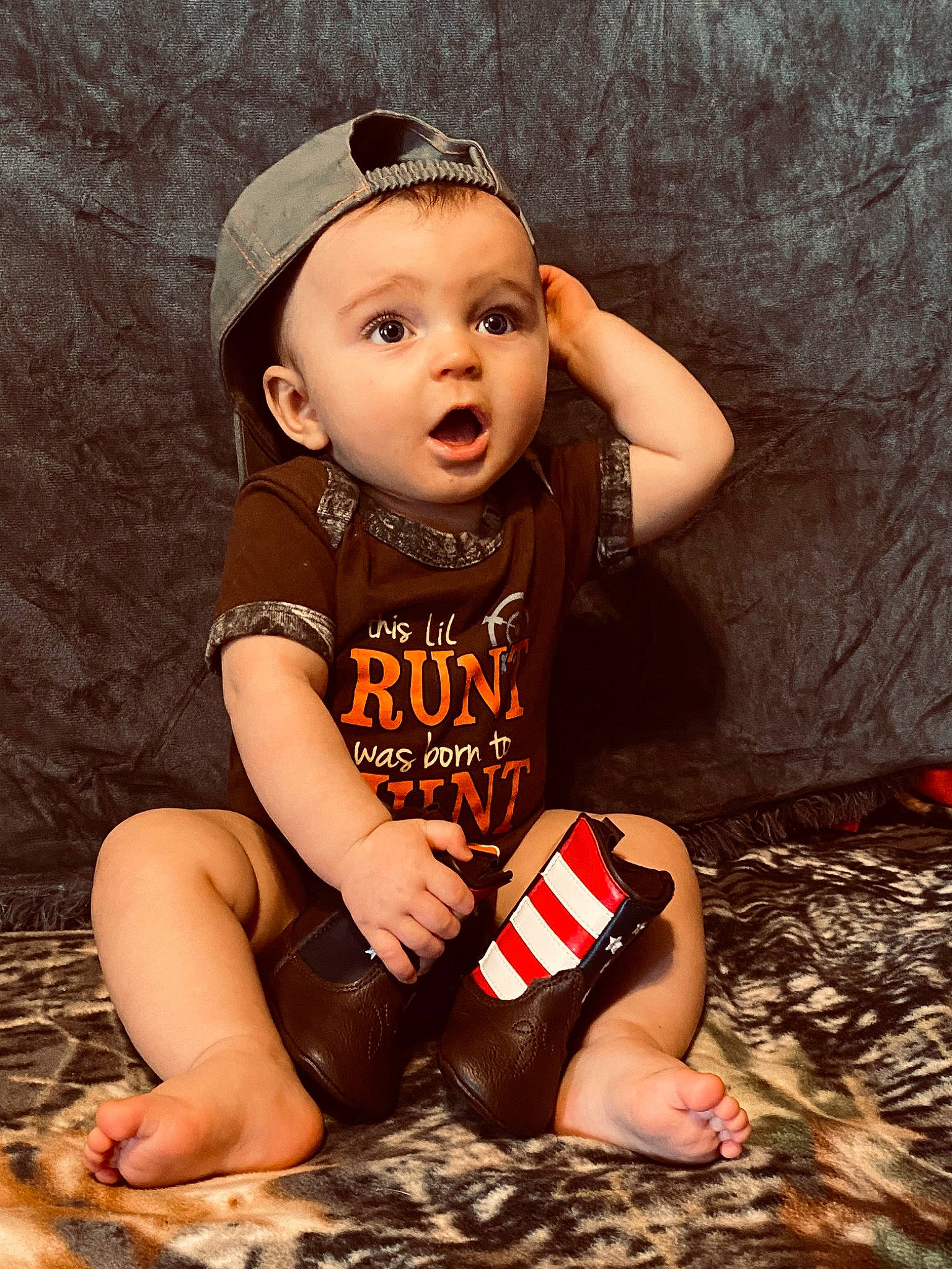 Cason is registered to the contest to win money with this photo: baby, baby_toddler_clothing, cap, child, face, fashion_accessory, flash_photography, foot, fun, happy, head, human_leg, lip, mouth, person, sitting, skin, sleeve, surprise, t_shirt