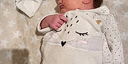 Mahëlle participe au concours pour gagner de l'argent avec cette photo : baby, newborn, sleeping, blanket, onesie, infant, cute, plush_toy, soft, cozy, star_pattern, sleep, child, indoors, peaceful, clothing, hand, face, head, resting