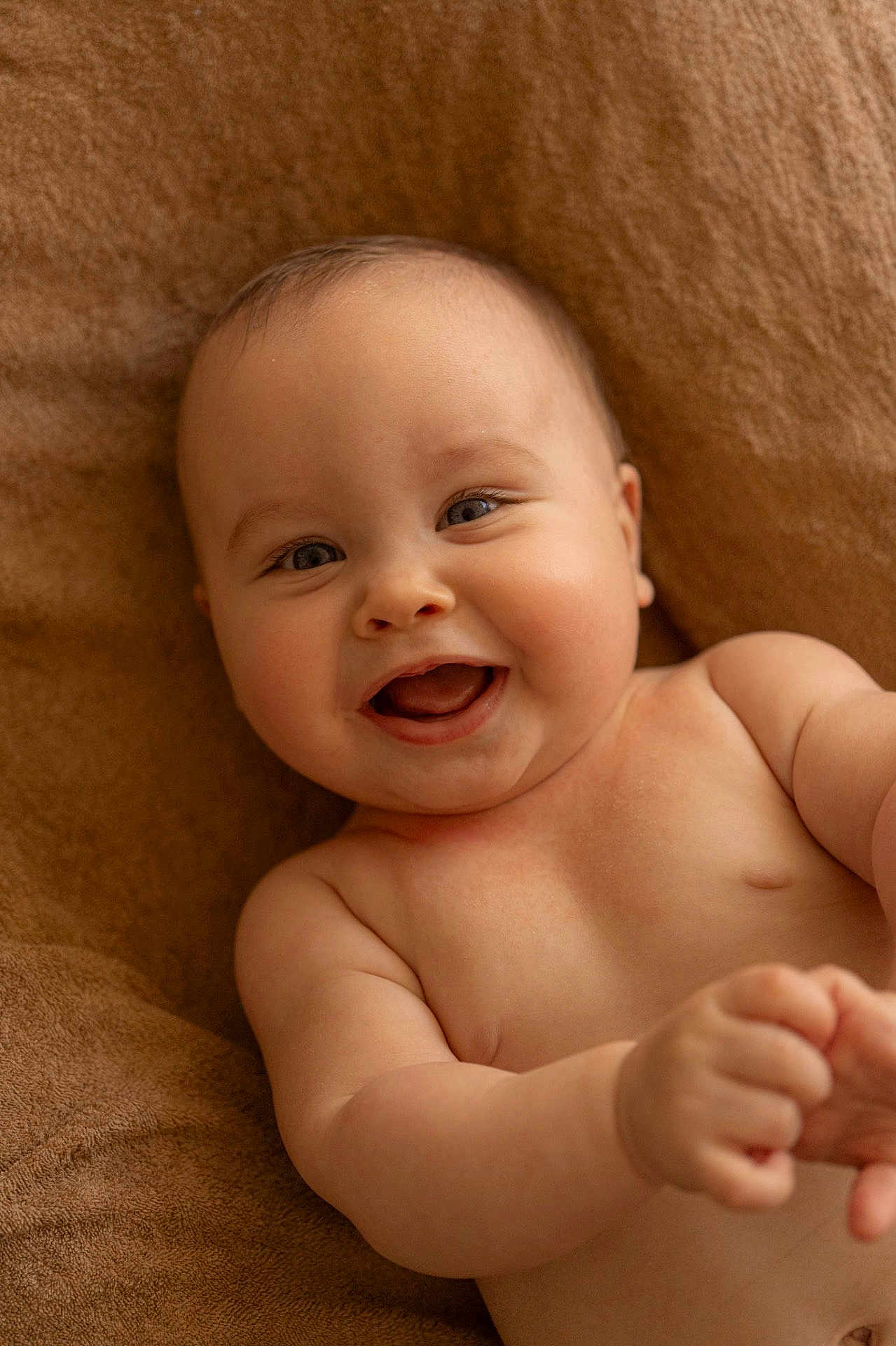 Matéo participe au concours pour gagner de l'argent avec cette photo : baby, infant, smiling, laughing, chubby_cheeks, bare_torso, skin, portrait, close_up, eyes, mouth, hands, fingers, blanket, towel, cozy, adorable, cute, lying_down, studio_lighting