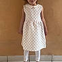 barefoot, beige_wall, casual, child, cute, fashion, girl, happy, indoor, leggings, looking_at_camera, person, pigtails, portrait, red_hearts, smile, standing, tile_floor, white_dress, young_child