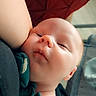 baby, infant, face, closeup, sleeping, skin, arm, clothing, green_shirt, red_background, indoor, child, newborn, peaceful, resting, portrait, soft_light, cute, person, human