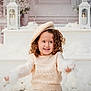 beret, child, cotton, cozy, curly_hair, cute, decorations, festive, flowers, happy, holiday, indoor, lantern, playful, portrait, smiling, soft_lighting, sweater, white, winter_theme