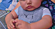Ian is registered to the contest to win money with this photo: baby, child, person, face, arm, clothing, outdoor, greenery, chair, watch, hand, cute, infant, young, portrait, sitting, casual, pattern, nature, colorful