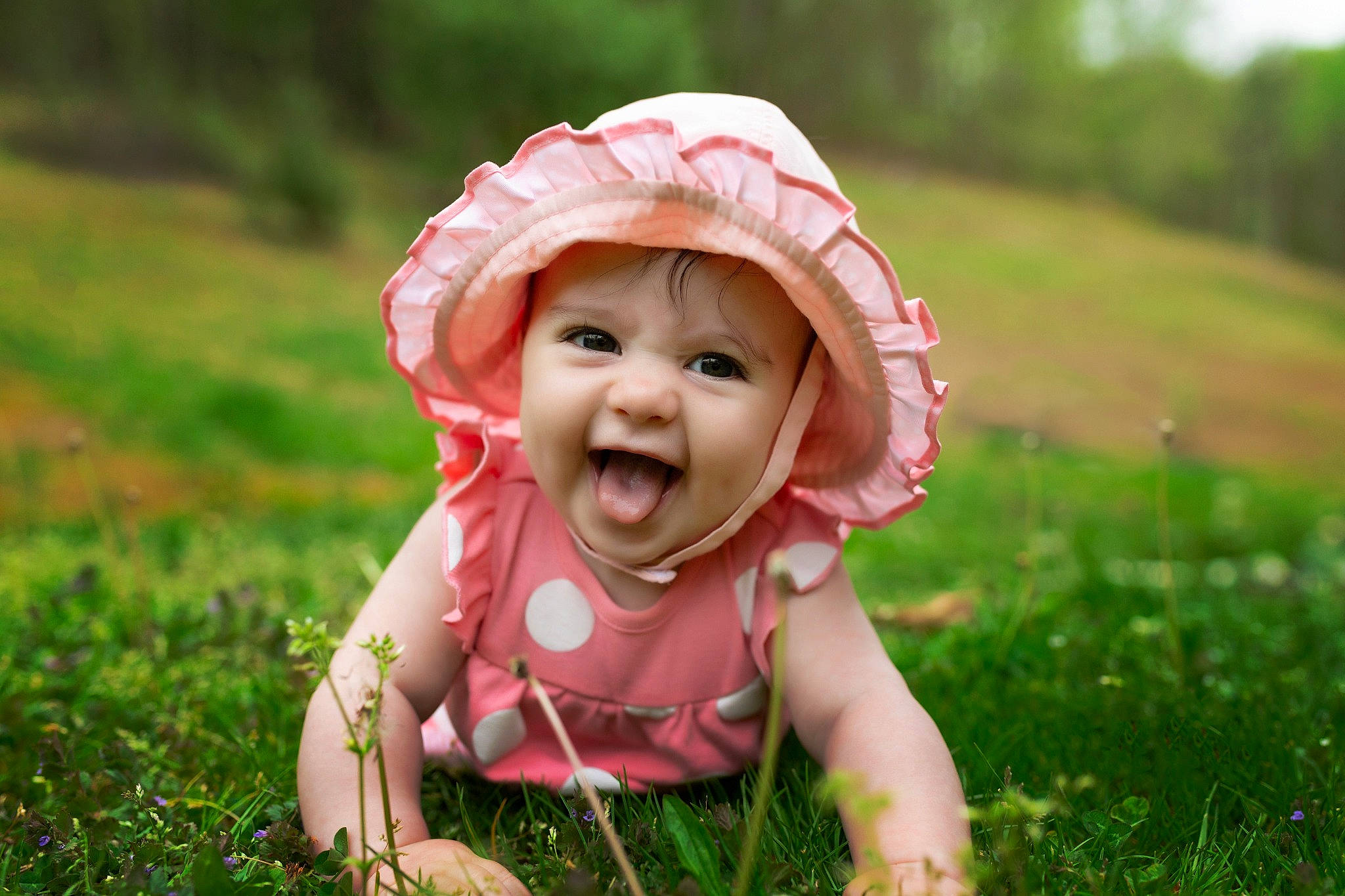 Zoey joined the competition — help win amazing prizes! baby, baby_laughing, baby_toddler_clothing, dress, eye, face, gesture, grass, grassland, happy, hat, head, headgear, headwear, human_body, people_in_nature, person, plant, smile, sun_hat