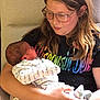 Savannah is registered to the contest to win money with this photo: child, baby, glasses, blanket, indoor, holding, seated, affection, person, portrait, young_girl, newborn, clothing, love, family, caring, casual, comfort, chair, smile