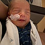 John Luke is registered to the contest to win money with this photo: newborn, baby, infant, blanket, medical_tube, smile, person, sleeping, clothing, indoors, bed, healthcare, cute, wrapped, face, head, hospital, rest, peaceful, tiny