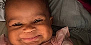 Jenesis joined the competition — help win amazing prizes! baby, smile, face, pink_clothing, butterfly_pattern, bed, blanket, child, infant, happy, cute, portrait, curly_hair, dimples, closeup, lying_down, soft_light, indoors, young_child, person