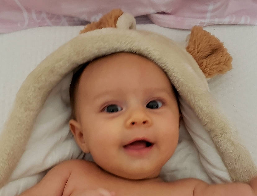 Jessica is registered to the contest to win money with this photo: baby, cap, cheek, child, comfort, ear, eye, eyelash, gesture, happy, hat, headwear, iris, linens, lip, nose, person, skin, smile, sun_hat