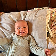 Liam joined the competition — help win amazing prizes! baby, smiling, infant, pajamas, bed, pillow, happy, face, child, sleepwear, person, wooden_headboard, cozy, indoor, cute, young_child, portrait, lying_down, blanket, home