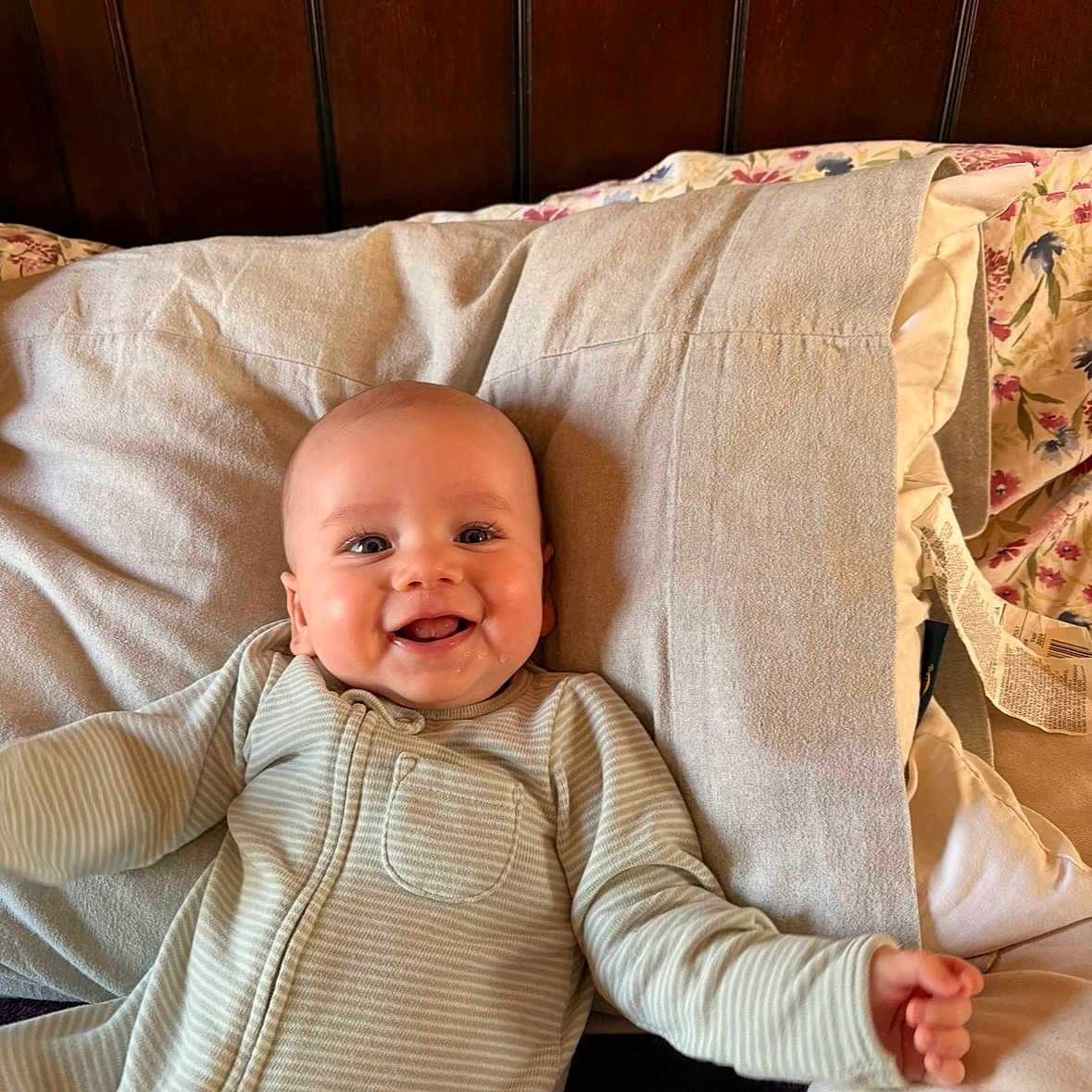 Liam joined the competition — help win amazing prizes! baby, smiling, infant, pajamas, bed, pillow, happy, face, child, sleepwear, person, wooden_headboard, cozy, indoor, cute, young_child, portrait, lying_down, blanket, home