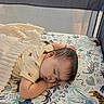 baby, sleeping, blanket, crib, crib_sheet, animal_print, infant, child, face, peaceful, indoors, soft_texture, cute, toddler, resting, bedtime, pajamas, playpen, comfort, nap