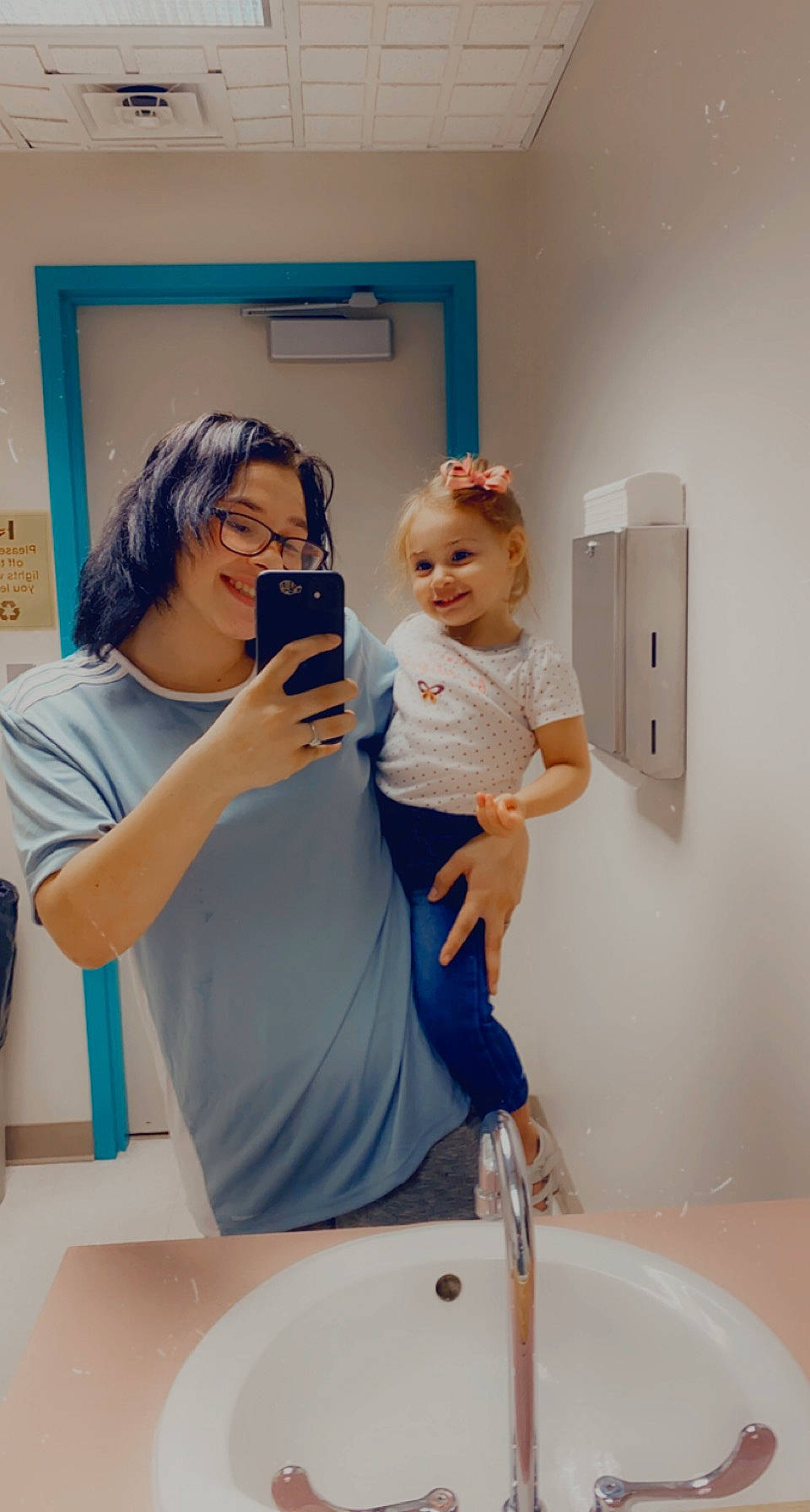 Ella is registered to the contest to win money with this photo: baby, bathroom, bathroom_sink, child, event, finger, fun, happy, joy, mirror, person, personal_care, picture_frame, plumbing_fixture, purple, service, sink, skin, smile, t_shirt