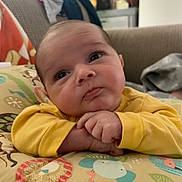 Antonio joined the competition — help win amazing prizes! baby, infant, yellow_clothing, pillow, animal_pattern, cute, face, hands, couch, indoor, child, portrait, expression, curious, lying_down, soft_lighting, home, cozy, young, adorable