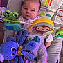Antonio is registered to the contest to win money with this photo: baby, infant, baby_seat, toy_frog, toy_monkey, toy_octopus, colorful, pajamas, carpet, indoor, child, cute, face, expression, plush_toy, seat, play, comfort, animal_print, soft