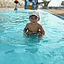 blue, cap, casual, child, curious, daytime, outdoor, person, playing, pool, recreation, shallow_water, sitting, summer, sunlight, swimming, toddler, water, water_activity, water_surface