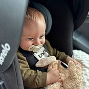 Kaïs a rejoint le concours — aidez-le/la à gagner de superbes lots ! baby, pacifier, car_seat, child, stuffed_animal, bunny, plush_toy, blue_eyes, clothing, seatbelt, infant, cute, toddler, soft_blanket, indoor, close_up, portrait, smiling, hands, cozy
