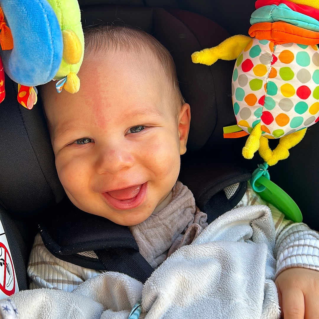 Arlo is registered to the contest to win money with this photo: baby, blanket, bodypart, clothing, cushion, face, finger, hand, happy, head, homedecor, laughing, person, photography, plush, portrait, smile, toy, transportation, vehicle